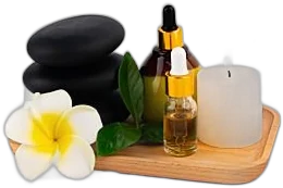 Spa stones, essential oils and a candle on a wooden tray